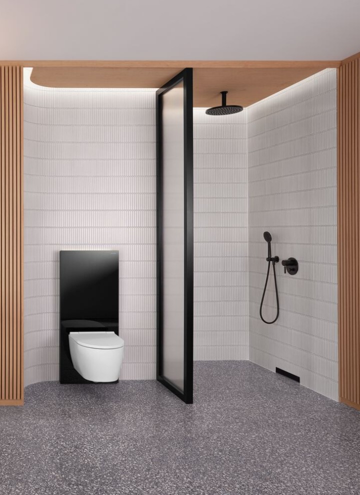Fürdőszoba faburkolatú fallal, valamint fekete-fehér színű zuhany- és WC-területtel