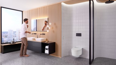 Fürdőszoba Geberit Option Plus Square tükörrel és fekete Geberit ONE fürdőszobabútorokkal, előtte pedig egy férfi (© Geberit)