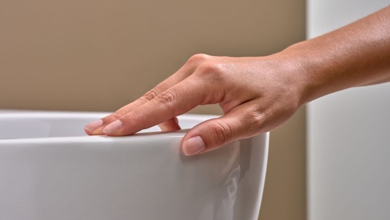 Egy kéz végigsimítja a speciális KeraTect® mázzal bevont WC-t Egy kéz végigsimítja a speciális KeraTect® mázzal bevont WC-t