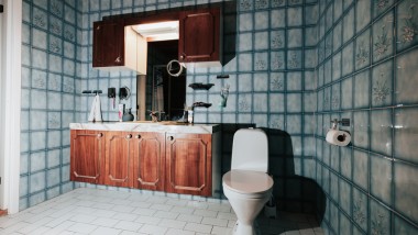 Fürdőszoba kék csempével és álló WC-vel
