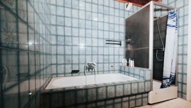 Fürdőszoba kék csempével, zuhanyfülkével és fürdőkáddal