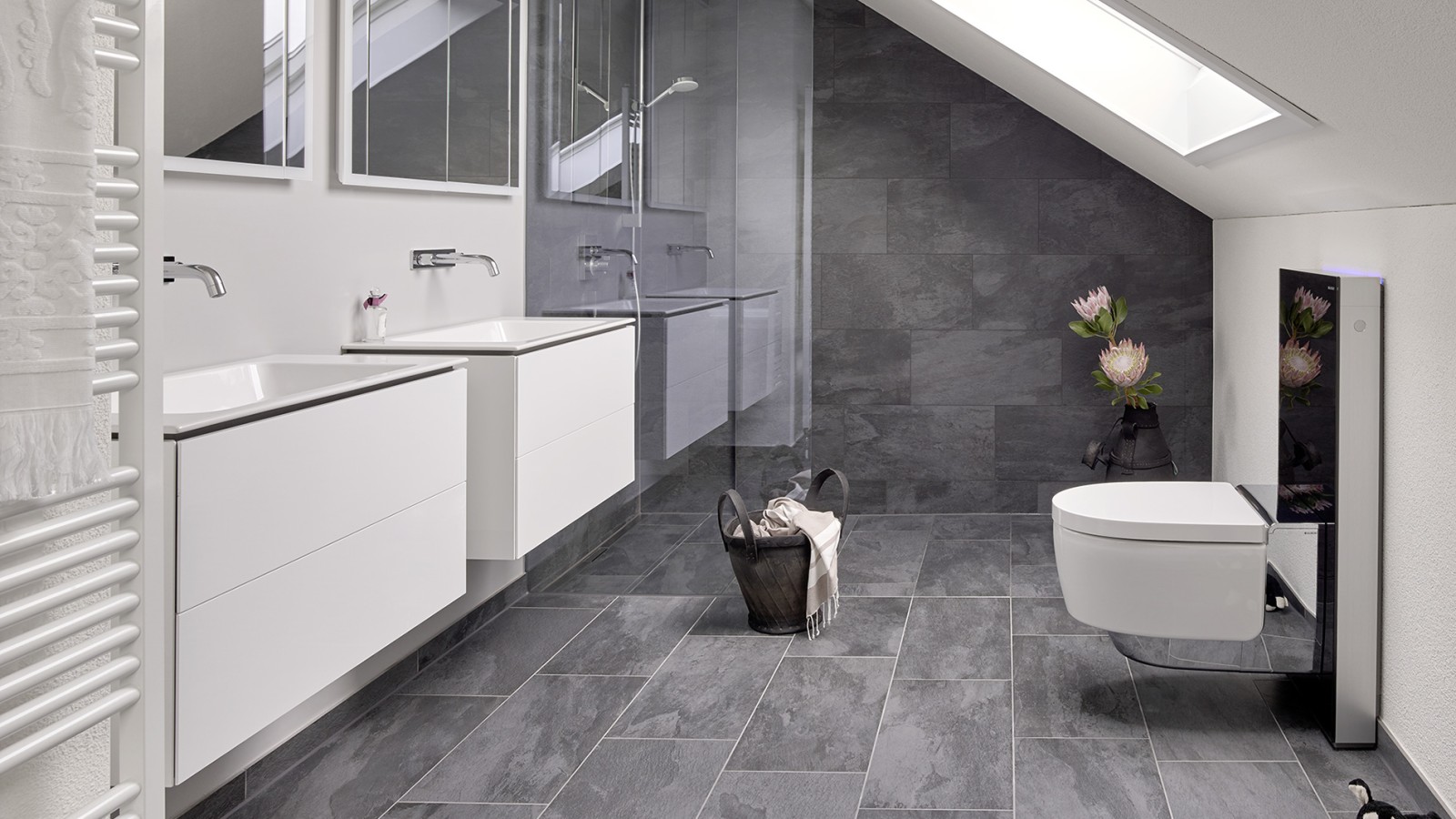 Fürdőszoba ferde tetővel és a Geberit ONE fürdőszobai termékcsalád termékeivel és Geberit AquaClean Monolith-tal