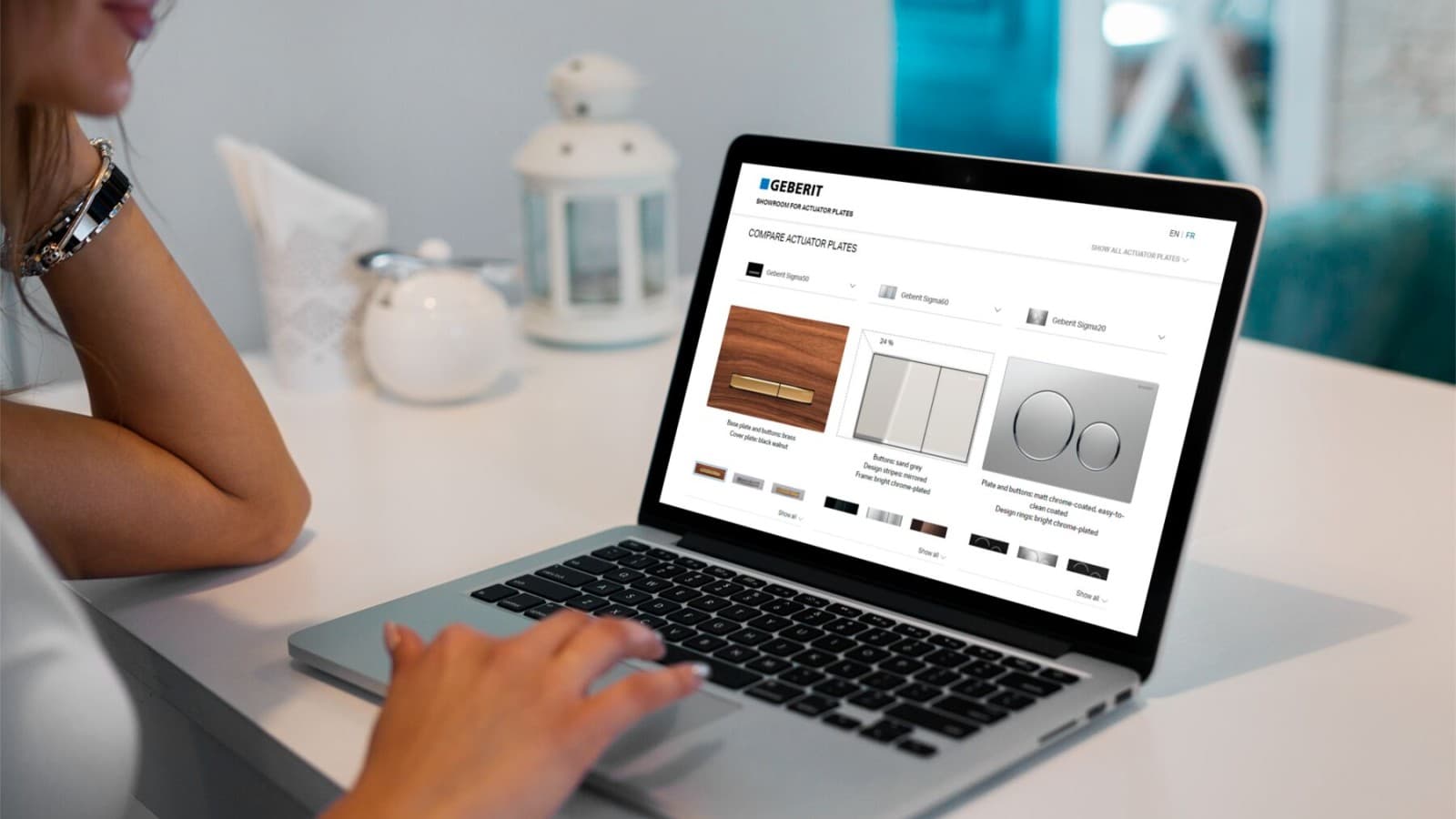 Egy hölgy, aki összehasonlítja a Geberit működtetőlapokat Egy hölgy, aki összehasonlítja a Geberit működtetőlapokat