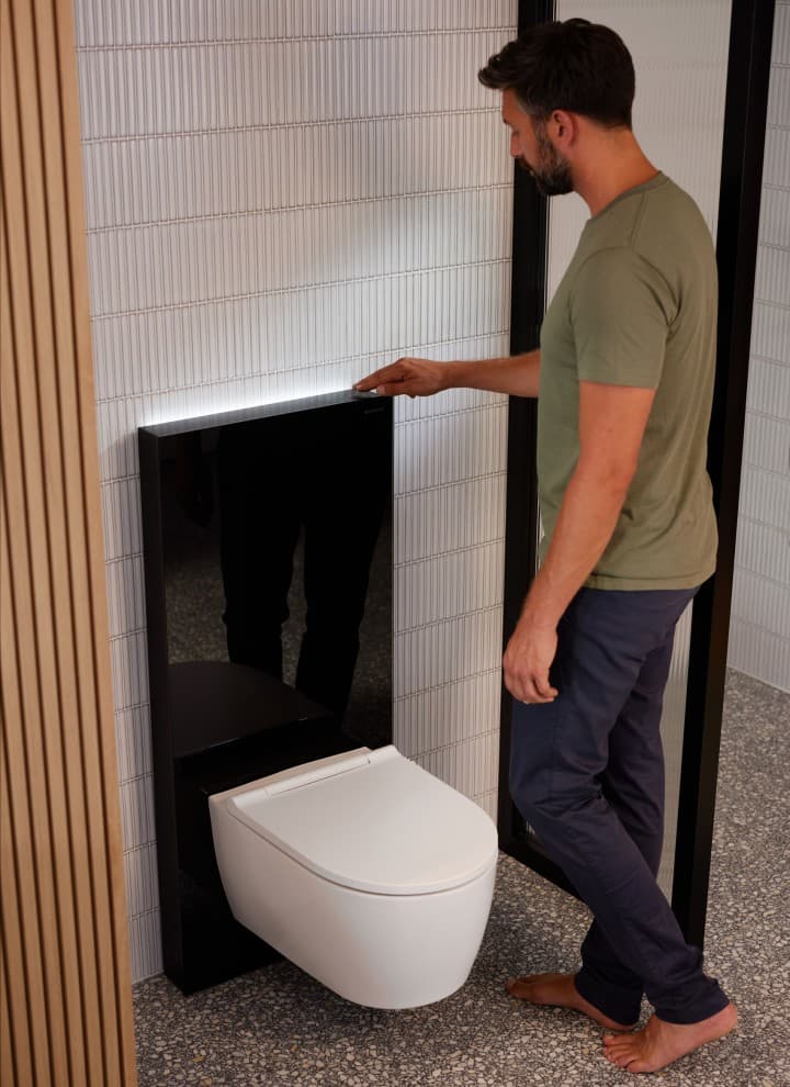 Férfi egy ComfortLight világítással felszerelt Geberit Monolith Plus mellett