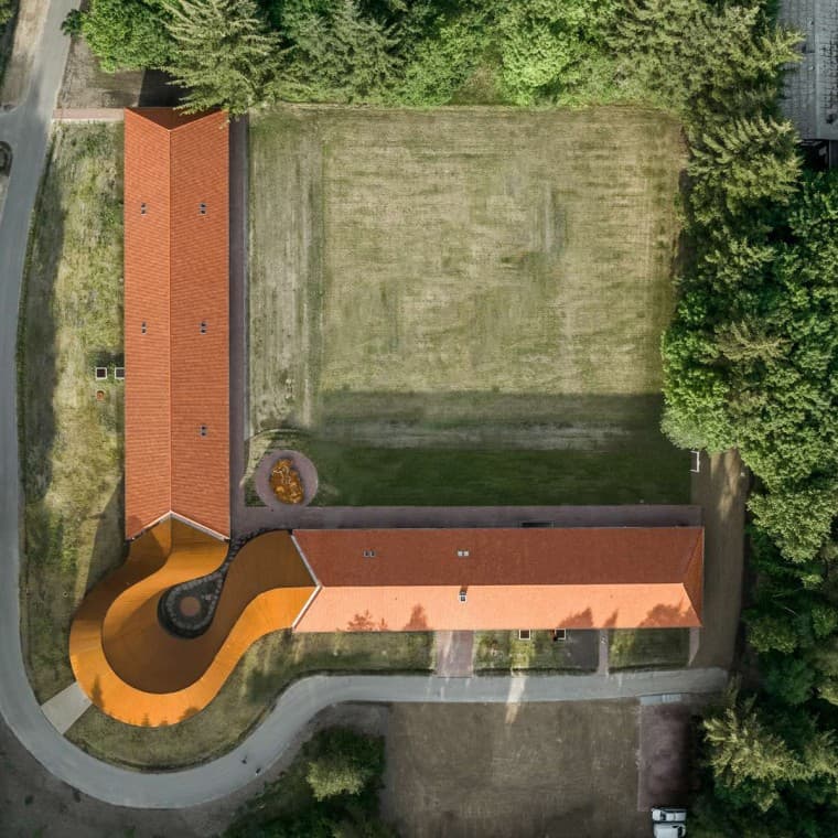 A felülnézeten a kerek új épület látható, amely összeköti a két, cseréptetős történelmi épületet (© R_Hjortshoj) A felülnézeten a kerek új épület látható, amely összeköti a két, cseréptetős történelmi épületet (© R_Hjortshoj)